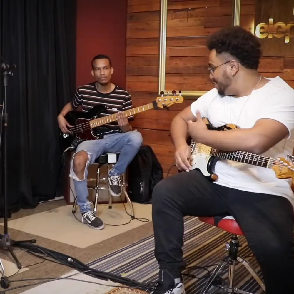 David Lopes tocando guitarra com a banda no estúdio